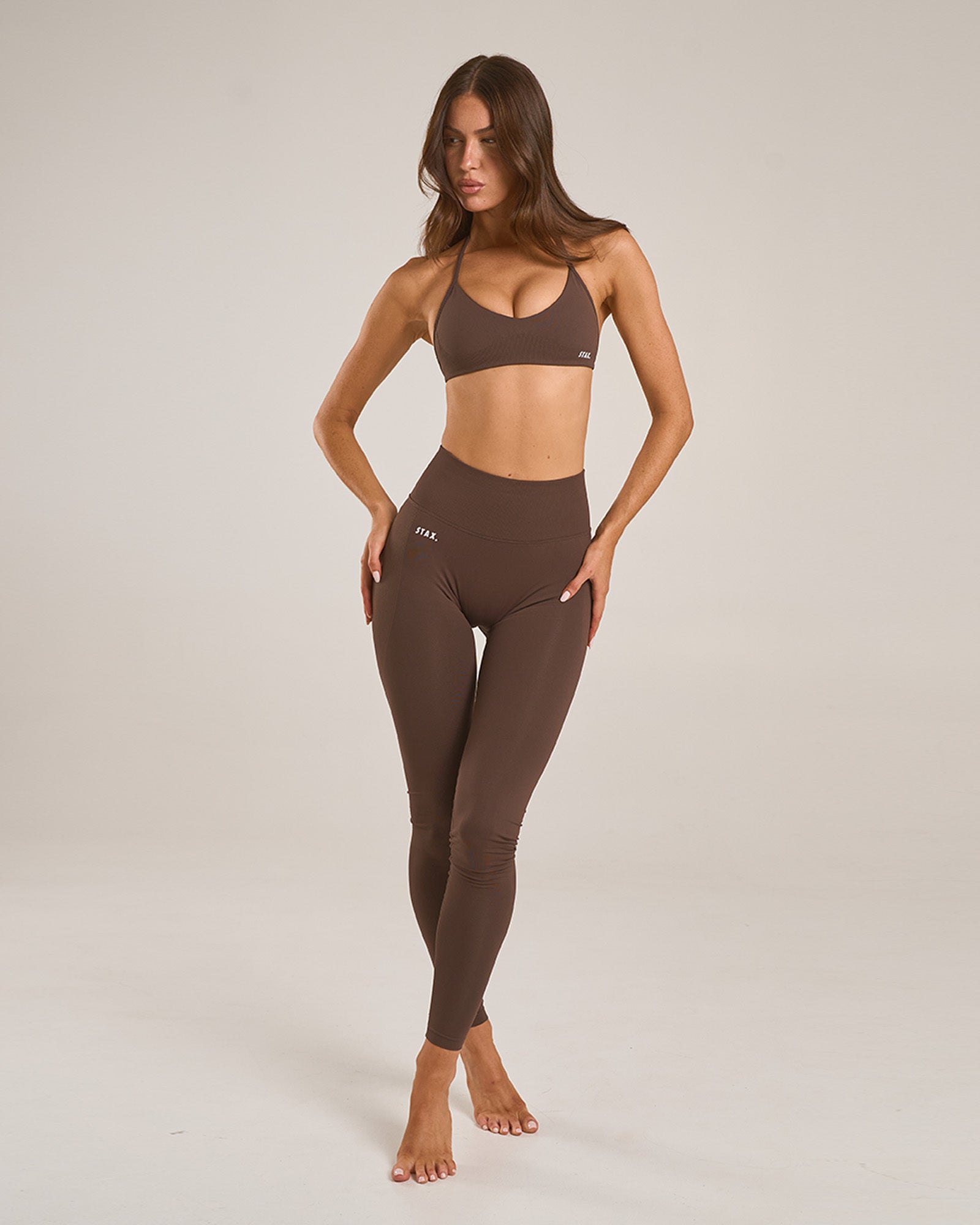 Front profile of model wearing STAX. Premium Seamless Skulpt Leggings in Brown emphasising flattering seamless design
