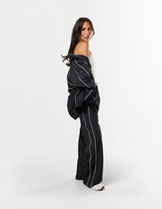 Side profile of STAX. Woven Track Jacket over the shoulder with matching woven track pants 