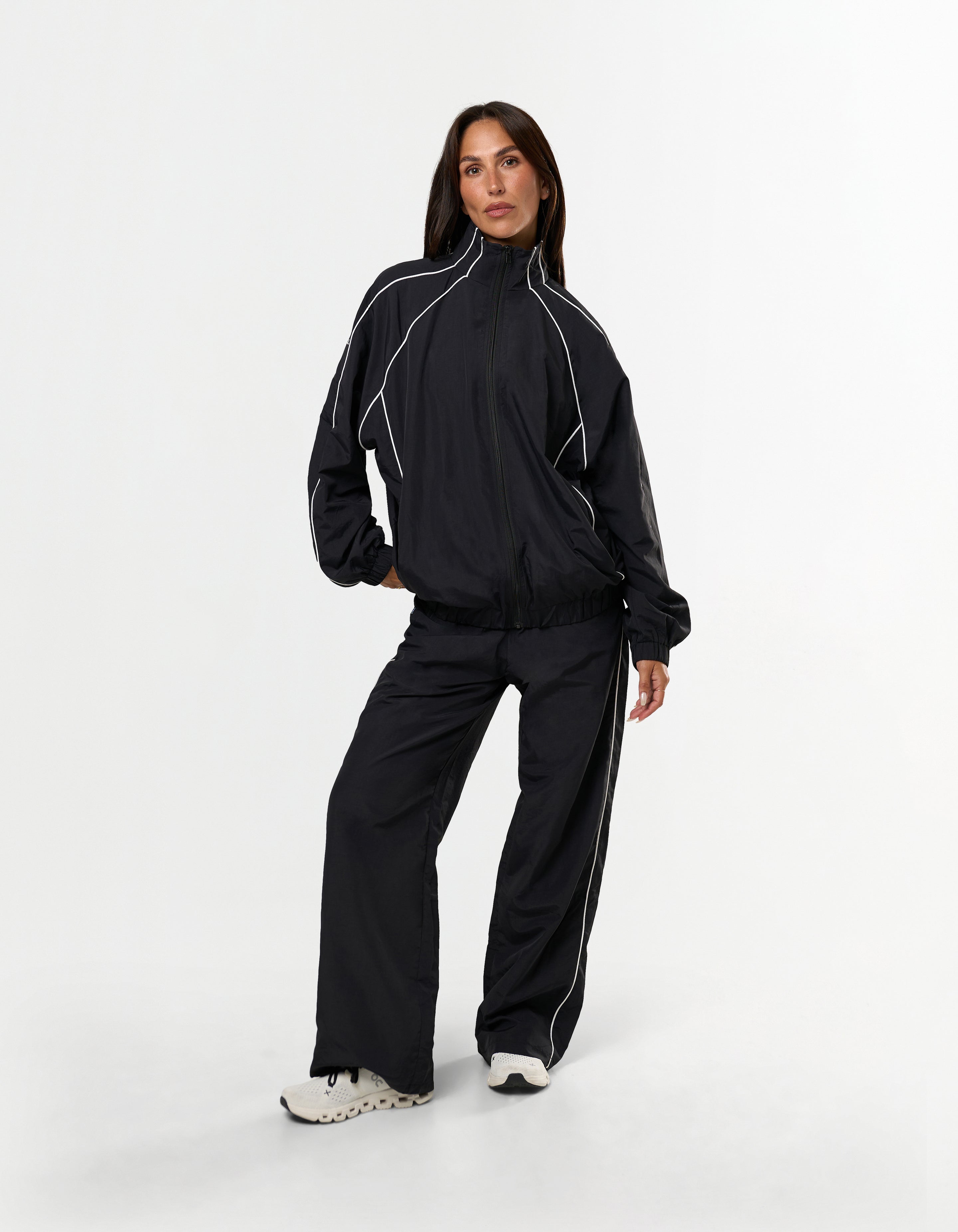 Front view of model wearing STAX. Woven Track Pants in Black with matching Woven Track Jacket showing contrast panelling 
