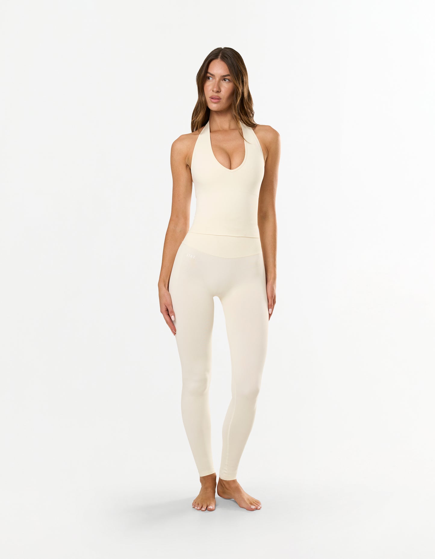 Front view of STAX. V Premium Seamless Skulpt Halter Tank in Cream showing ribbed waist panel and removable padding/cups