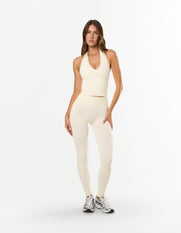 Front view of model wearing STAX. Premium Seamless Skulpt Leggings in Cream with matching skulpt halter tank in Cream