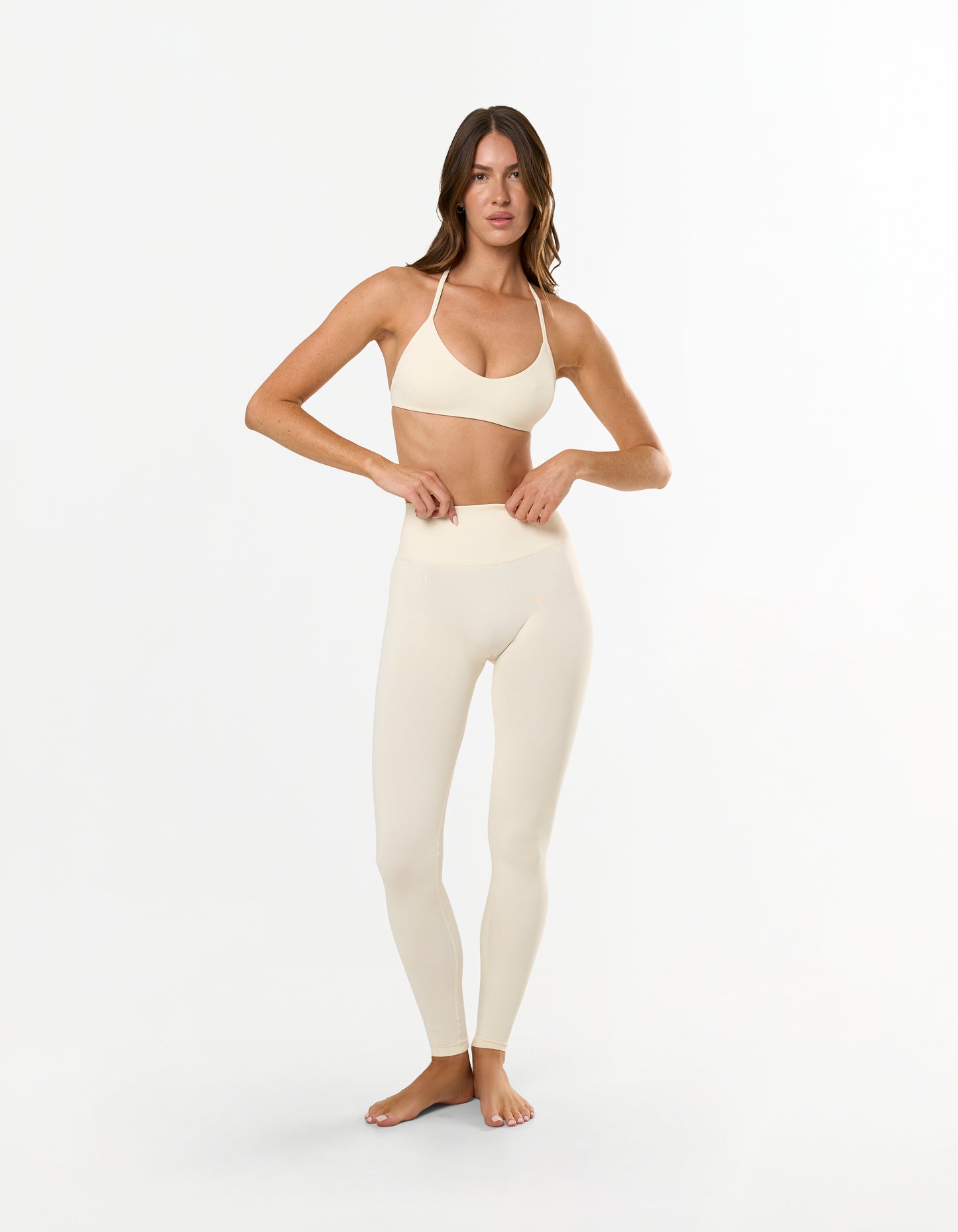 Front view of model wearing STAX. Premium Seamless Skulpt Leggings in Cream with matching skulpt bralette in Cream