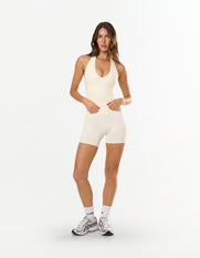 Front view of model wearing STAX. Premium Seamless Skulpt Halter Tank in Cream with matching skulpt bike shorts 