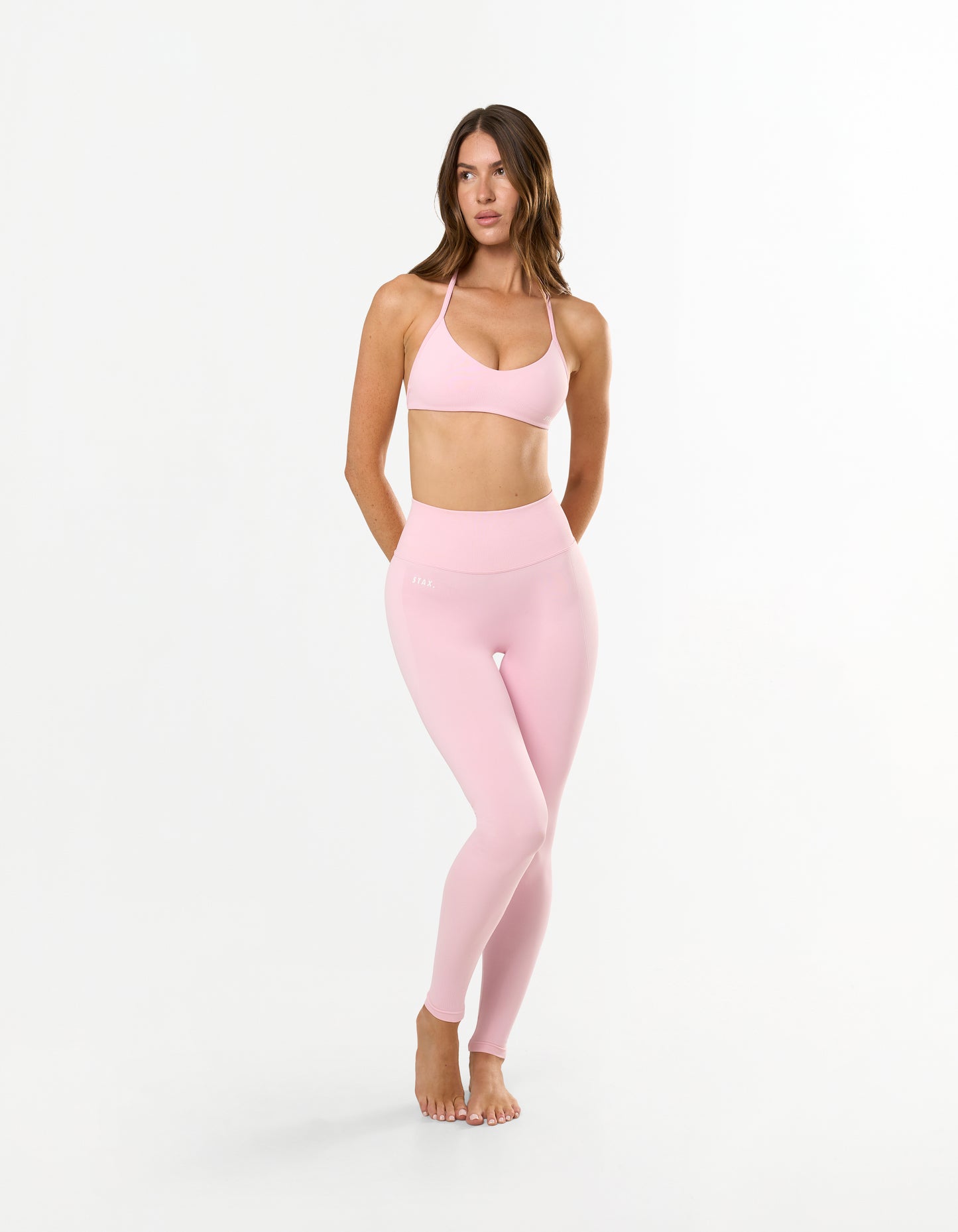 Front view of model wearing STAX. Premium Seamless Skulpt Leggings in Pink with matching skulpt bralette in pink