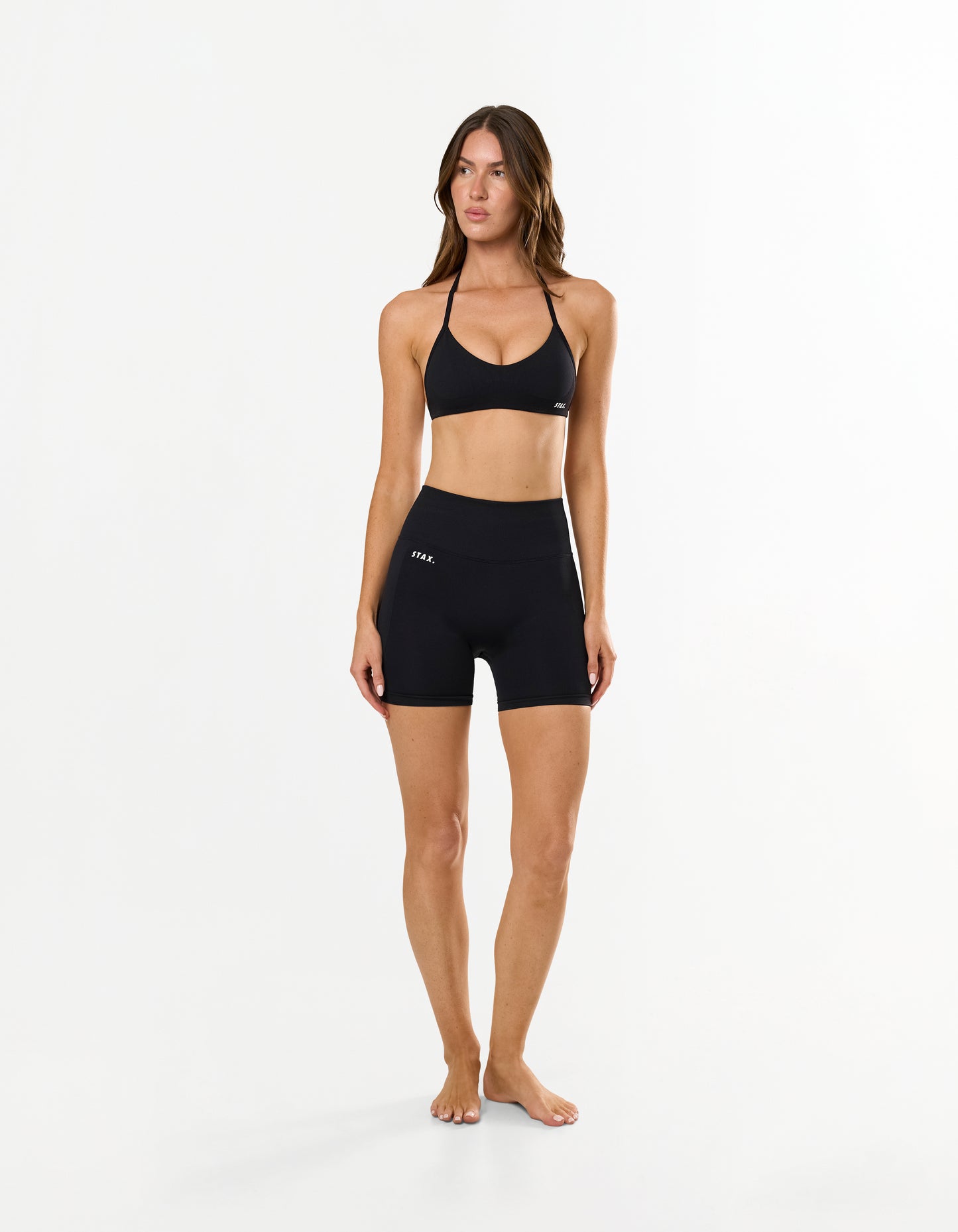 Front view of model wearing STAX. Premium Seamless Skulpt Bralette in Black with matching bike shorts 