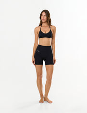 Front view of model wearing STAX. Premium Seamless Skulpt Bralette in Black with matching bike shorts 