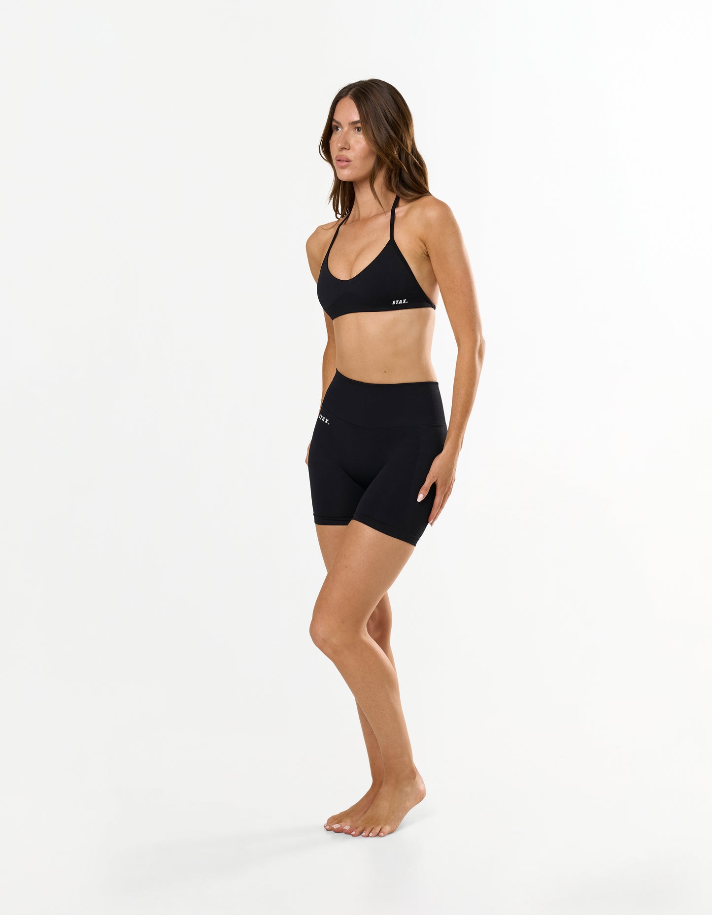 Front profile of STAX. Premium Seamless Skulpt Bralette in Black with compressive fit and strappy halter neck design