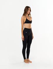 Side view of model wearing STAX. Premium Seamless Skulpt Bralette in Black with matching Premium Seamless Skulpt Full Length Tights