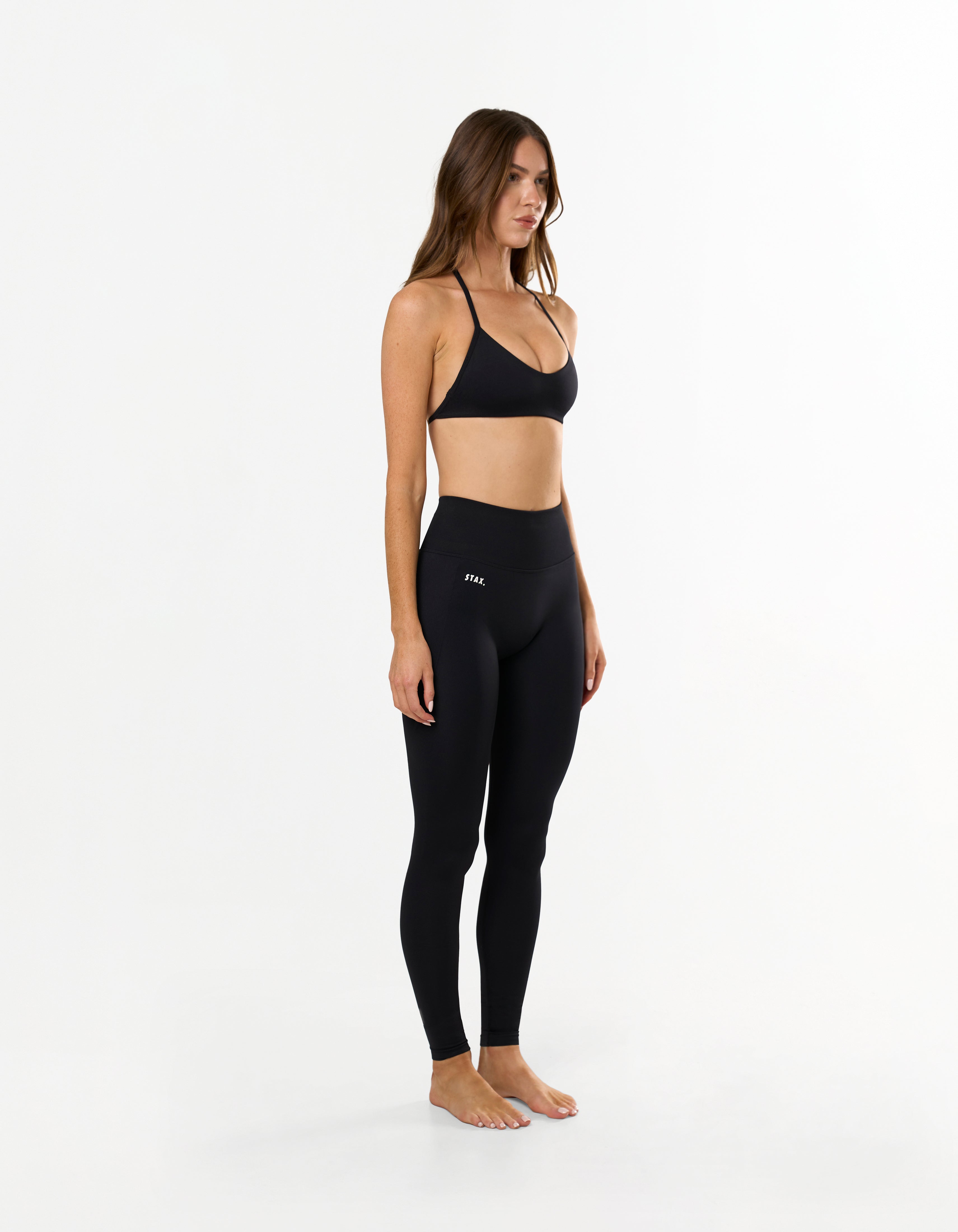 Front view of model wearing STAX. Premium Seamless Skulpt Tights in Black with matching skulpt bralette