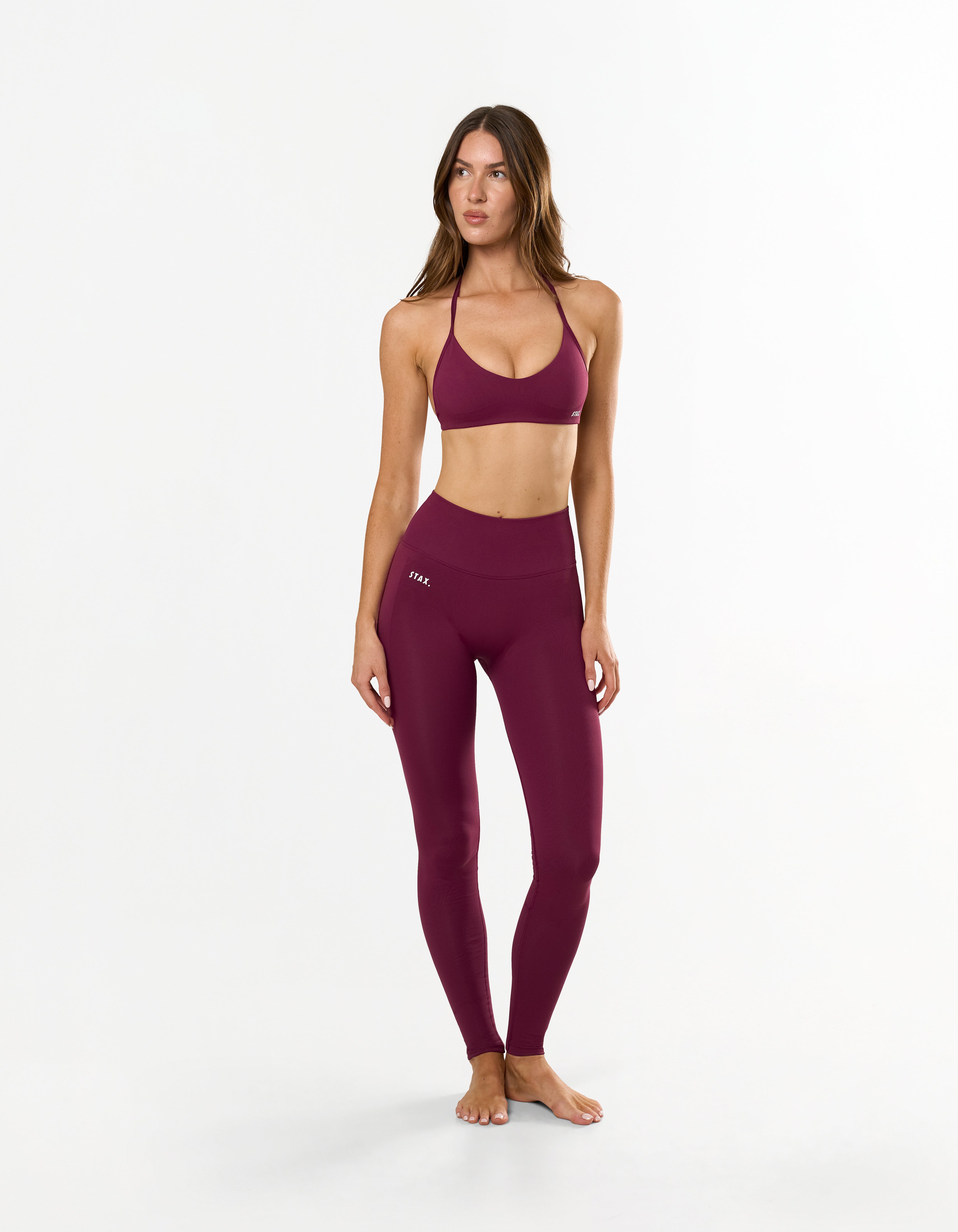 Front view of model wearing STAX. Premium Seamless Skulpt Tights in Burgundy with compressive ribbed waistband 