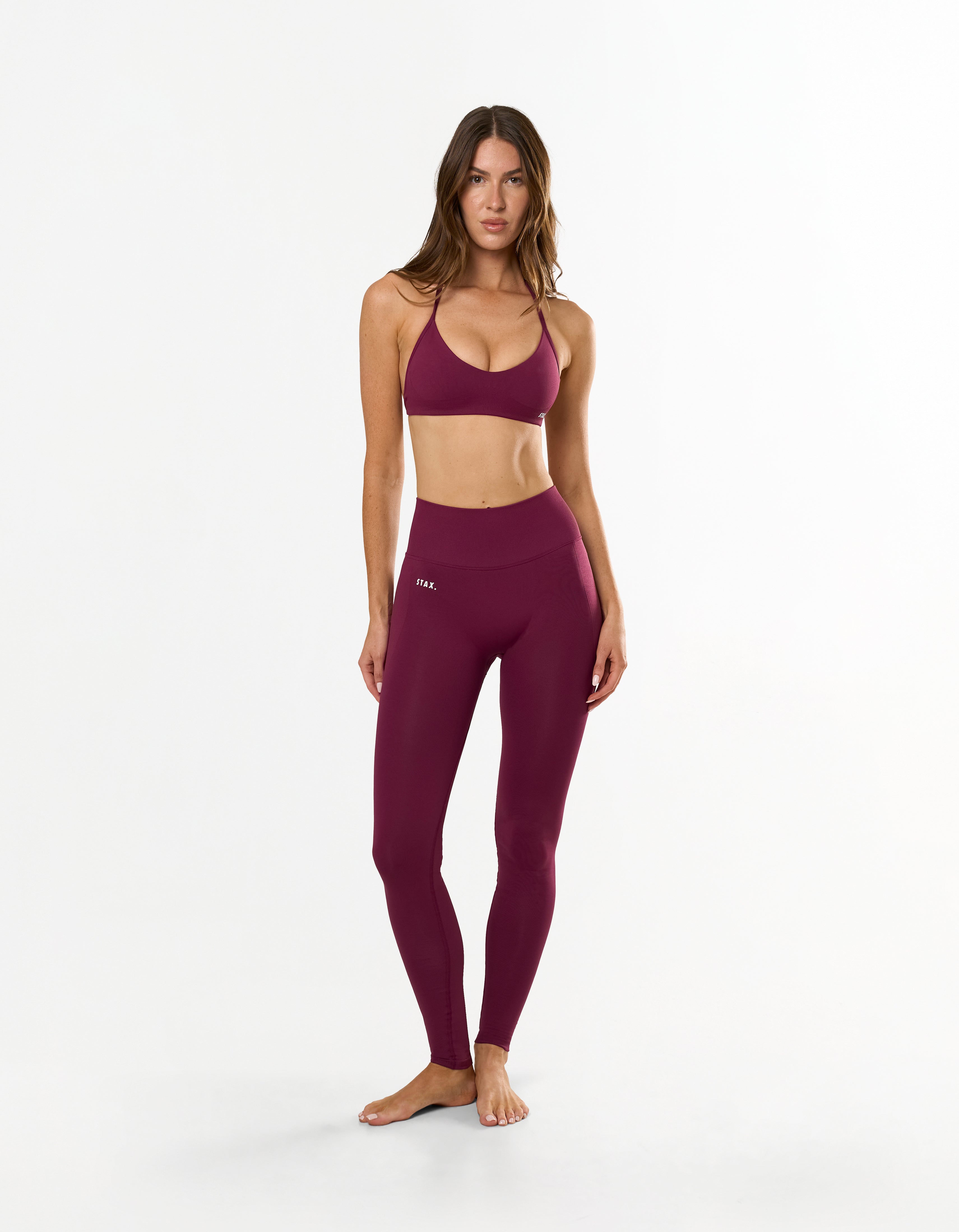 Front view of model wearing STAX. Premium Seamless Skulpt Bralette in Burgundy with matching Premium Seamless Skulpt Full Length Tights
