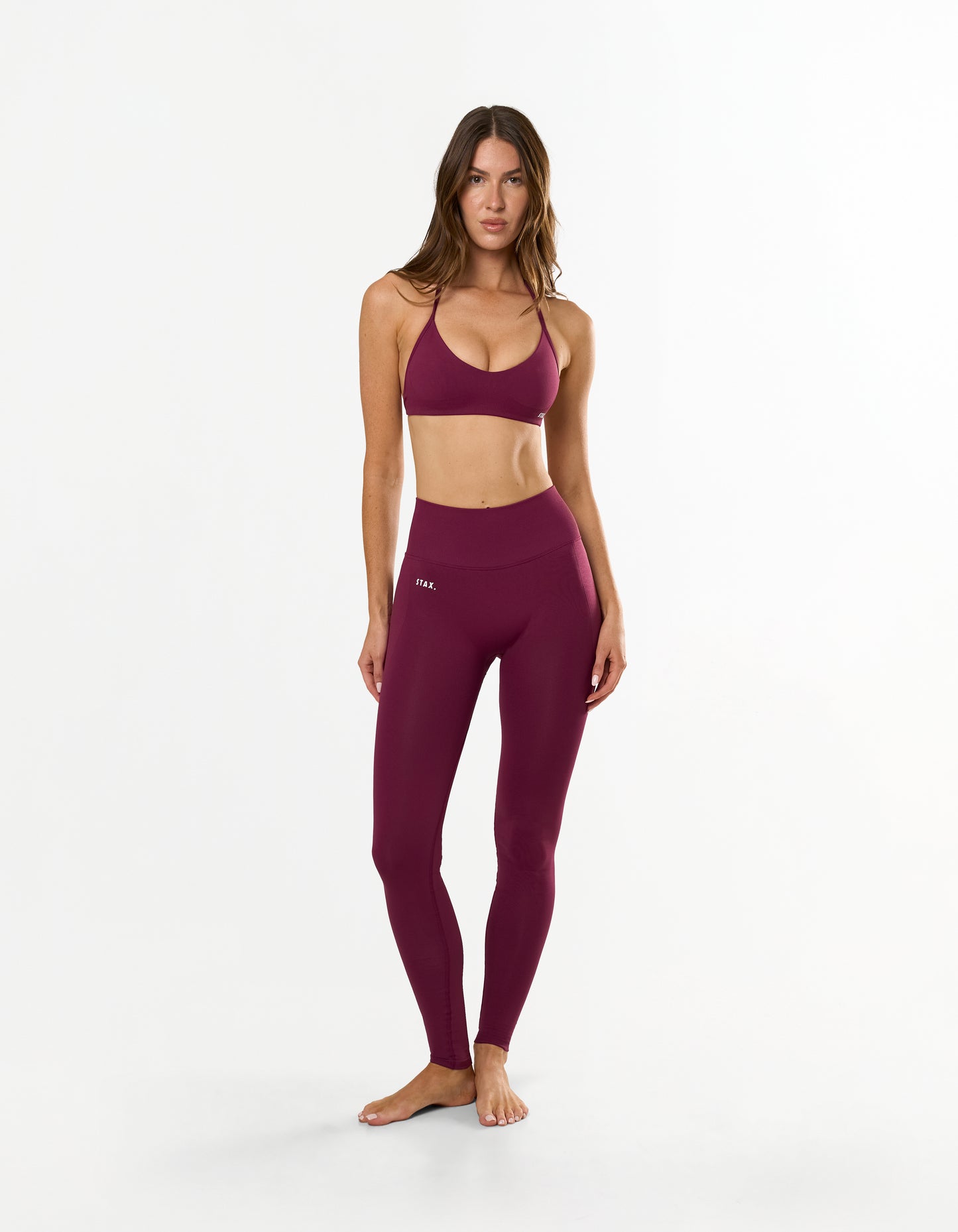 Front view of model wearing STAX. Premium Seamless Skulpt Bralette in Burgundy with matching Premium Seamless Skulpt Full Length Tights