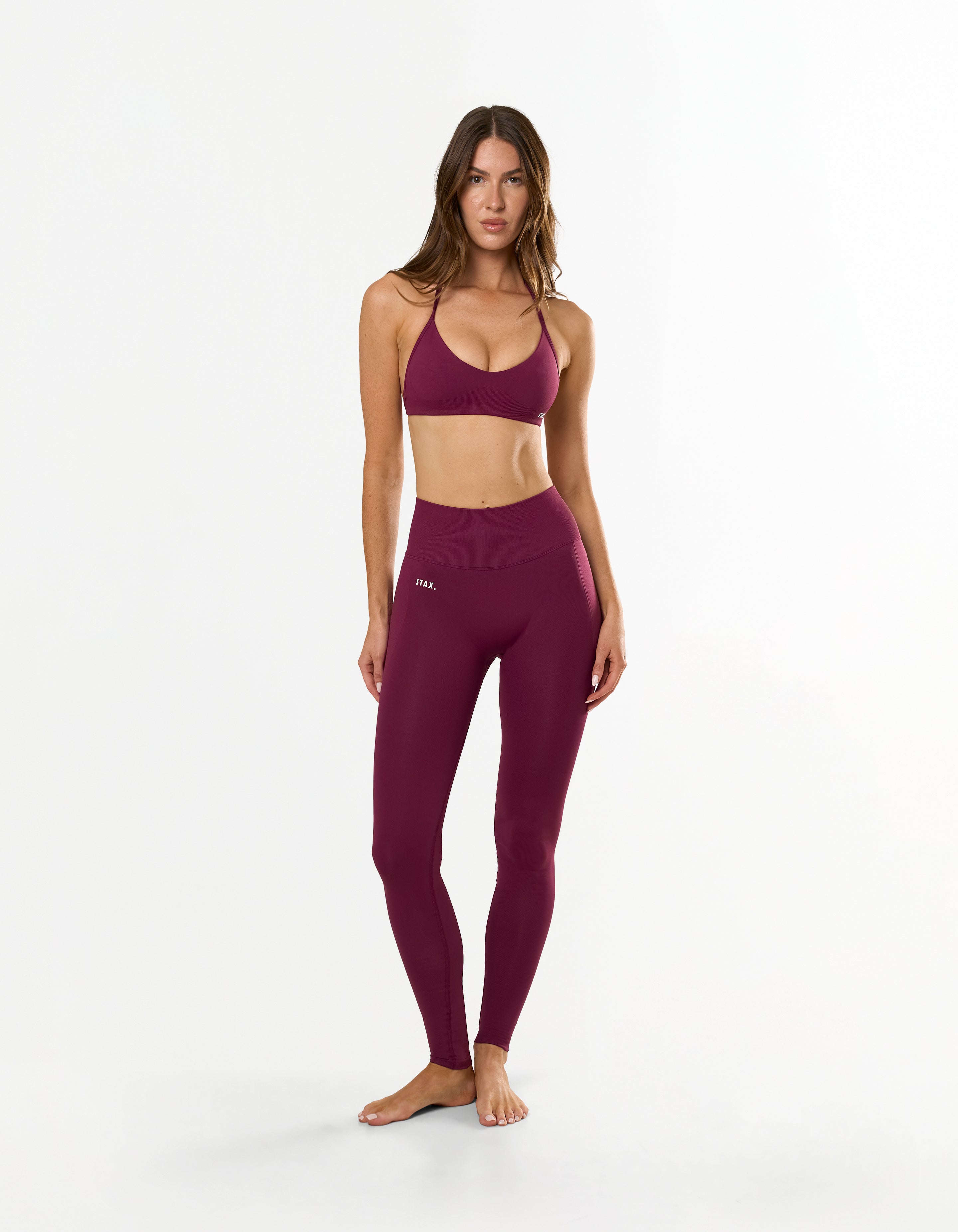 Front view of model wearing STAX. Premium Seamless Skulpt Bralette in Burgundy with matching Premium Seamless Skulpt Full Length Tights