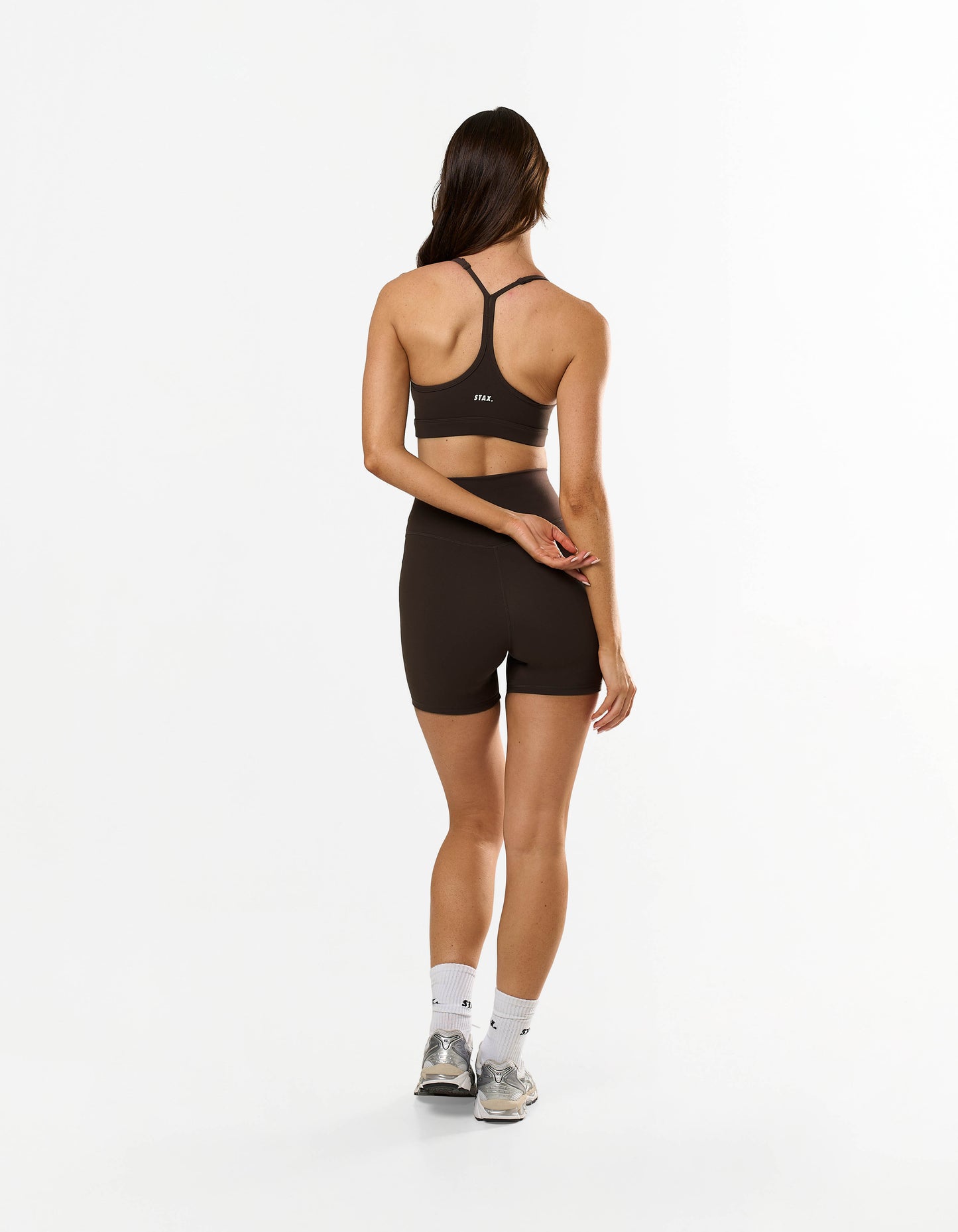 Back view of model wearing STAX. Strappy Crop NANDEX™ in Espresso with Removable cups / padding and matching bike shorts