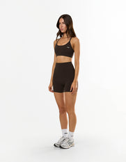 Side view of model wearing STAX. Strappy Crop NANDEX™ in Espresso with matching bike shorts and STAX. Crew socks