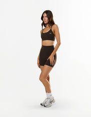 Front view of model wearing STAX. Strappy Crop NANDEX™ in Espresso with matching bike shorts 