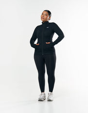 Front view of curve model wearing STAX. Zip Jacket NANDEX™ in Black with matching Full Length Tights NANDEX™ Original in Black