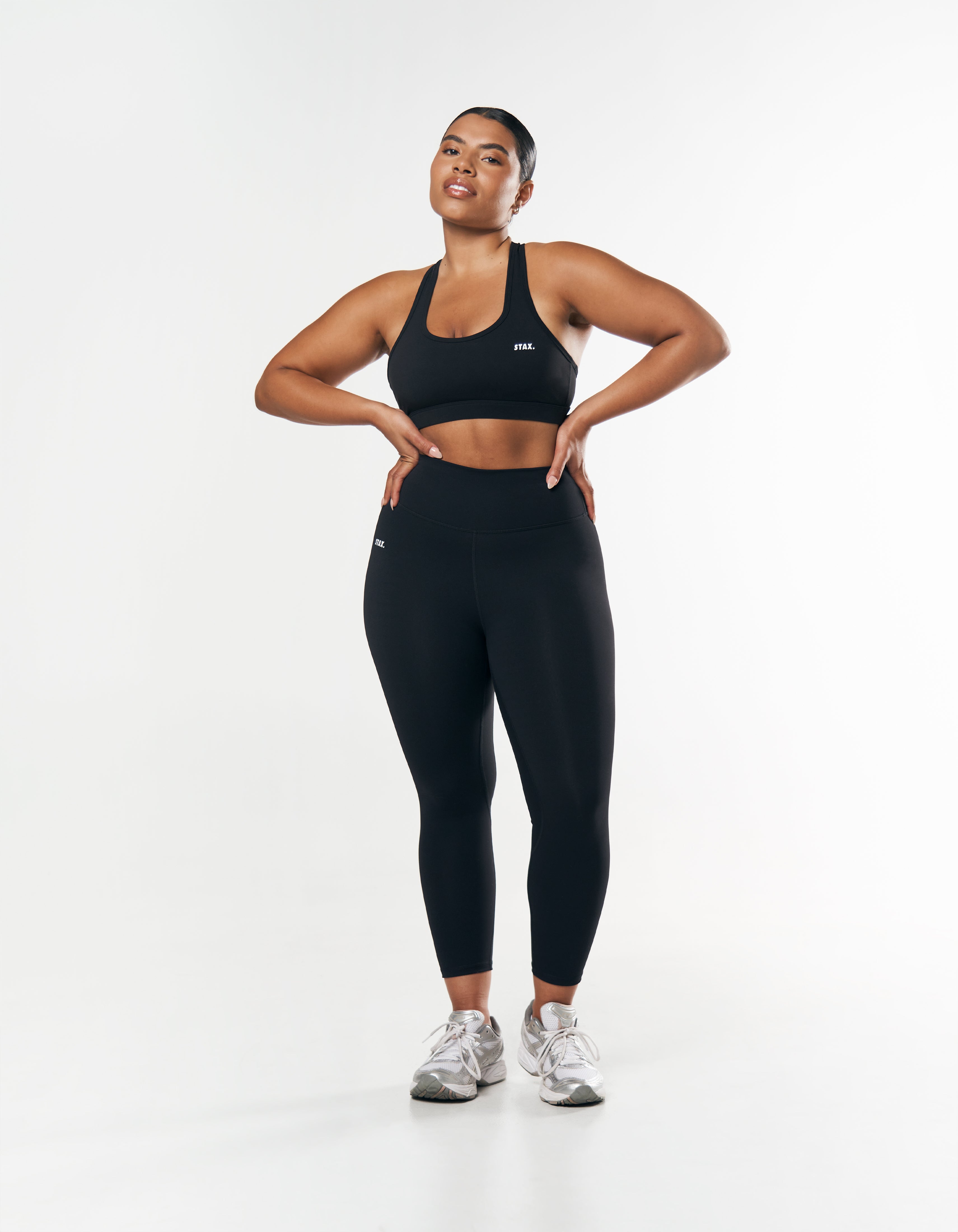 Model wearing everyday black tights styled with a black sports bra and sneakers
