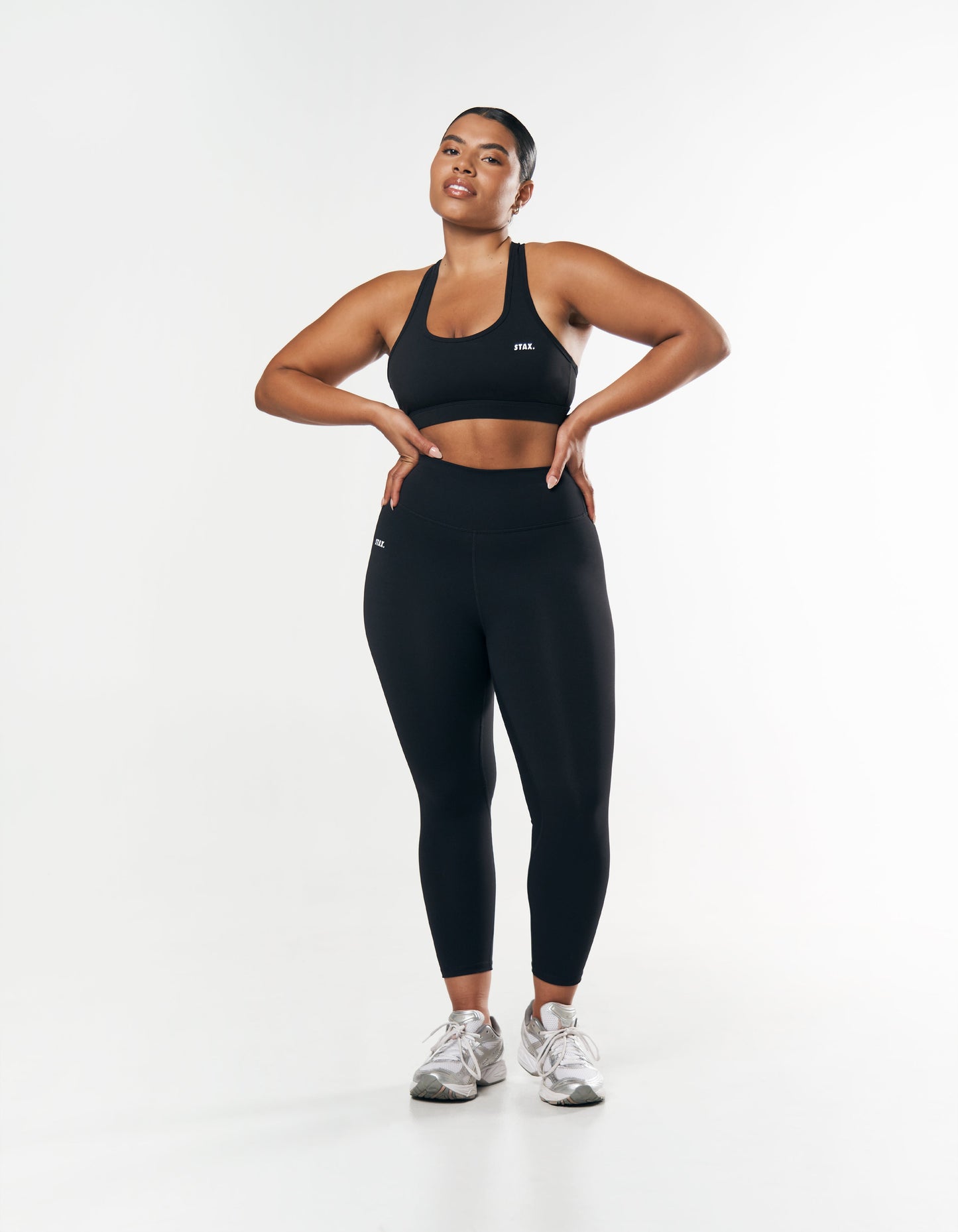 Model wearing everyday black tights styled with a black sports bra and sneakers