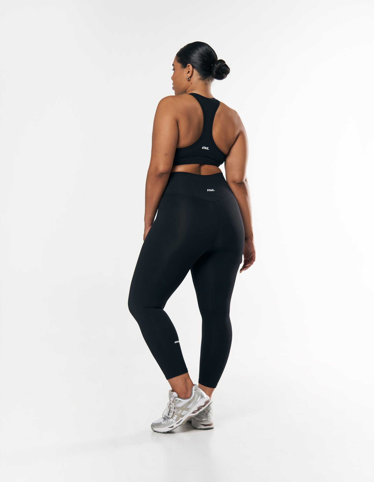Back view of squat proof black gym leggings featuring V-back seam