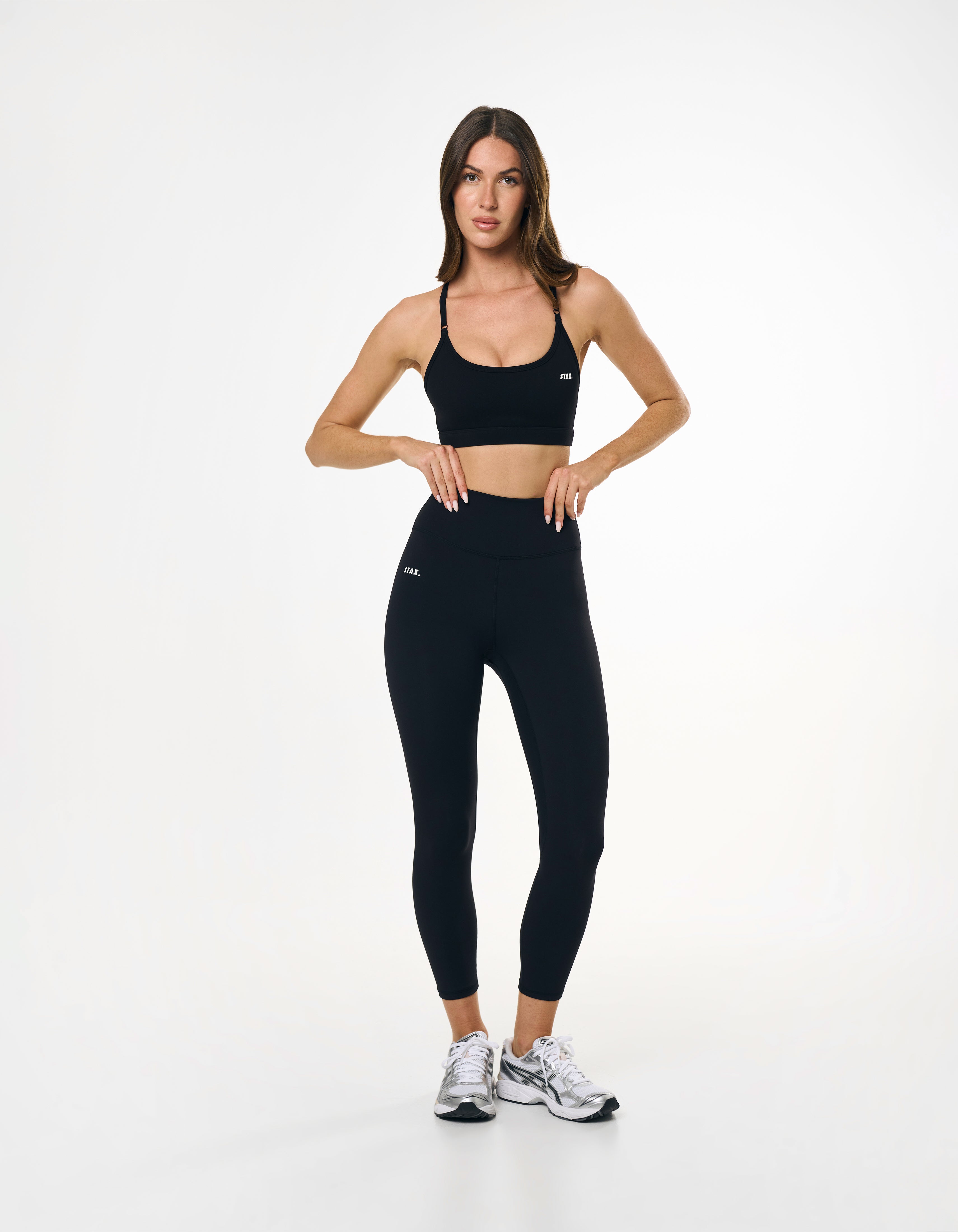 Front profile of model wearing high waisted black tights showing glute contour and seamless front