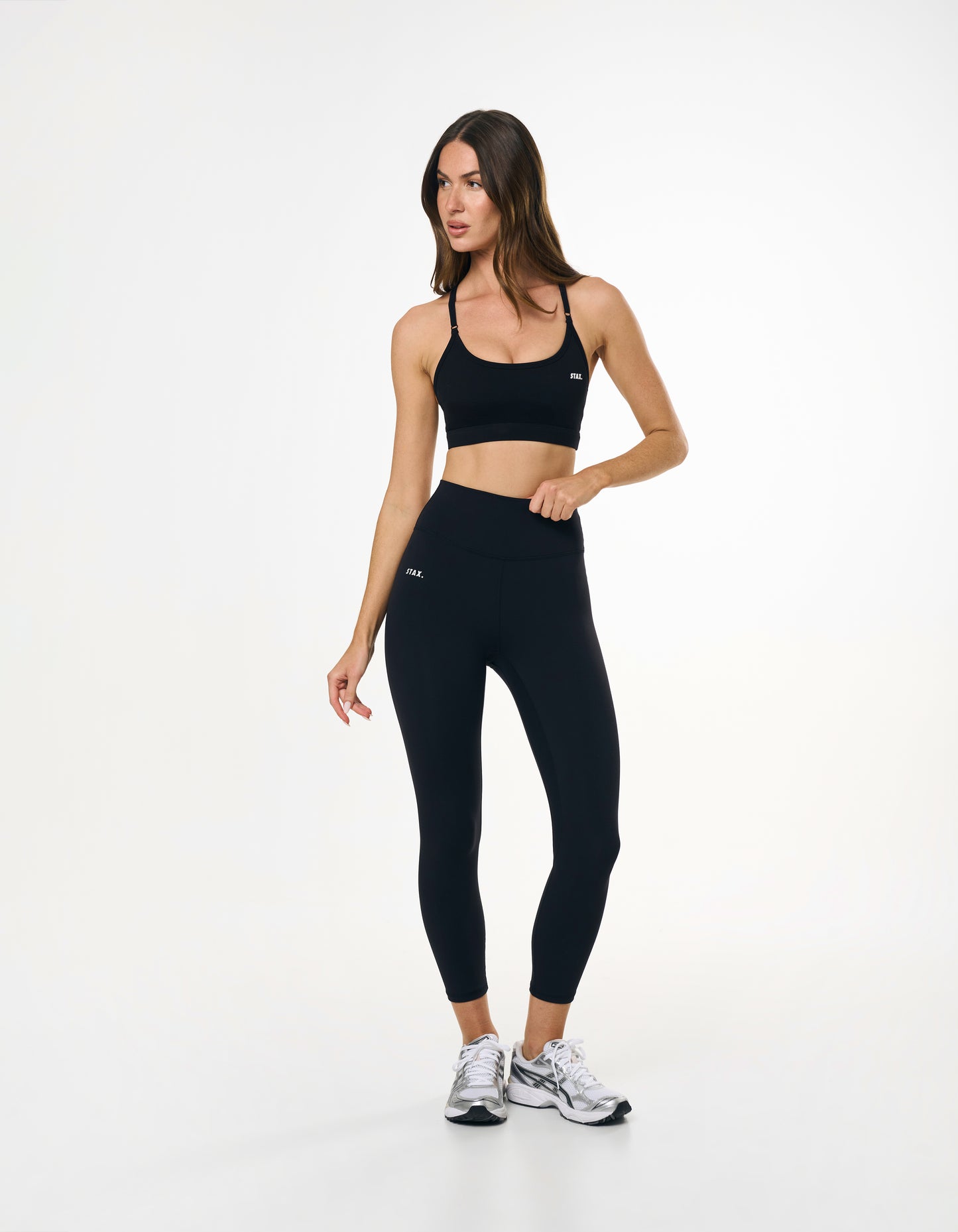 Model standing in everyday black tights styled with a black sports bra
